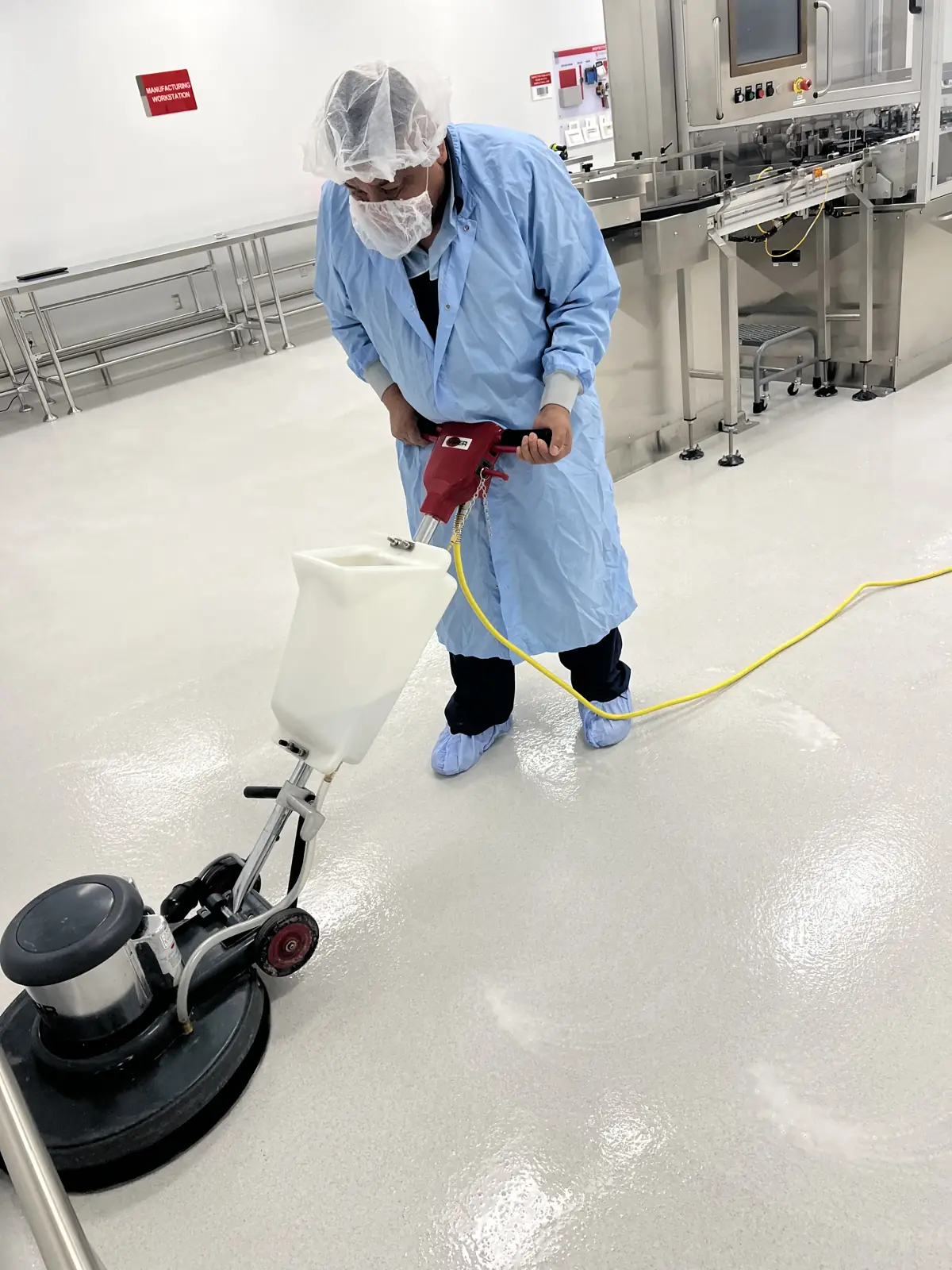 Gowned Nexara technician burnishing a cleanroom production floor