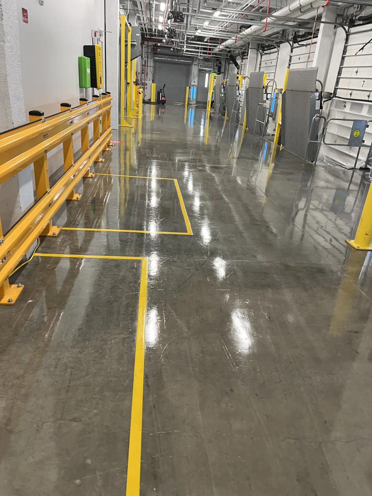 Polished concrete production floor with yellow safety rails