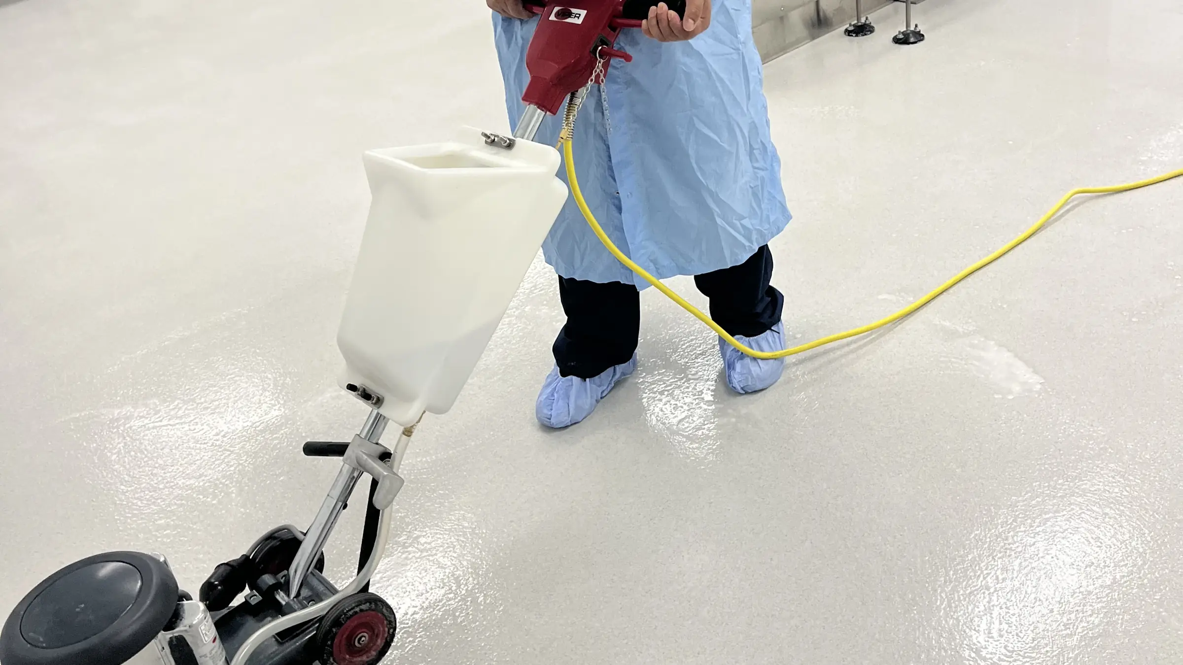 Gowned Nexara technician burnishing a cleanroom production floor