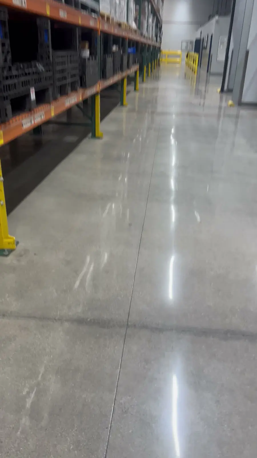 Polished concrete racking aisle reflecting the overhead lights after Nexara's polishing work