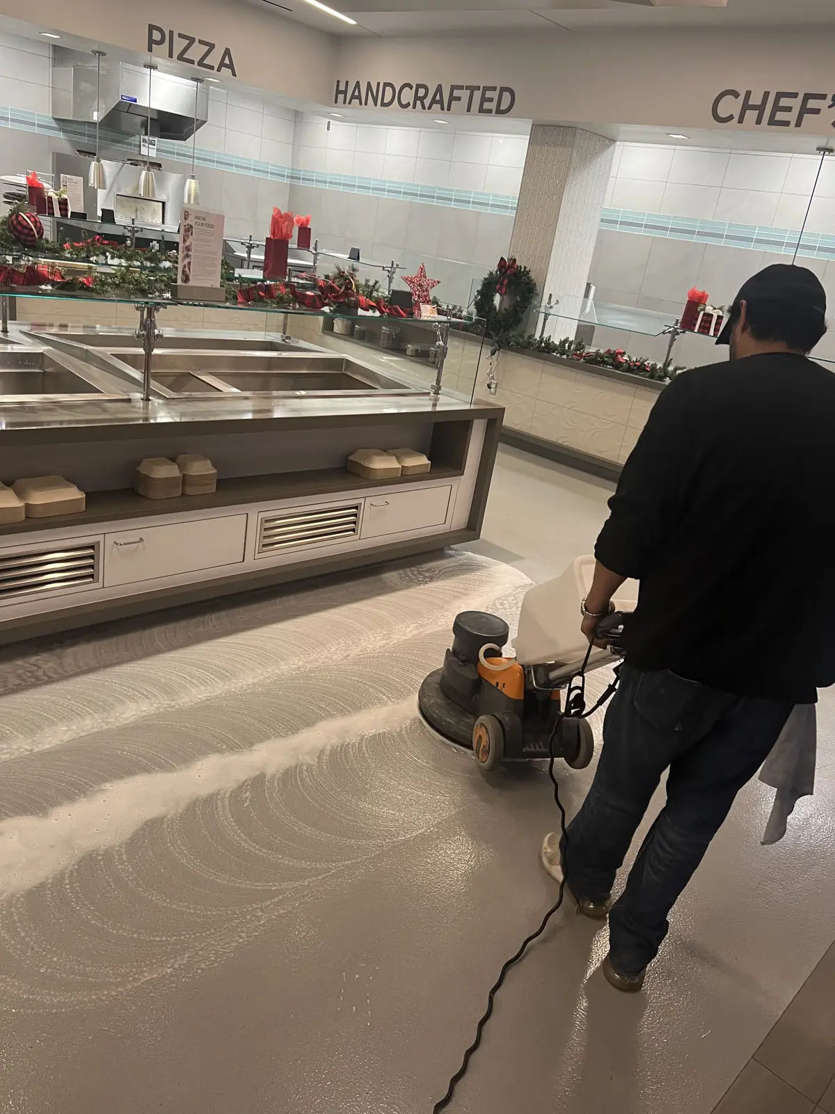 Nexara crew member burnishing a hard floor with a floor machine