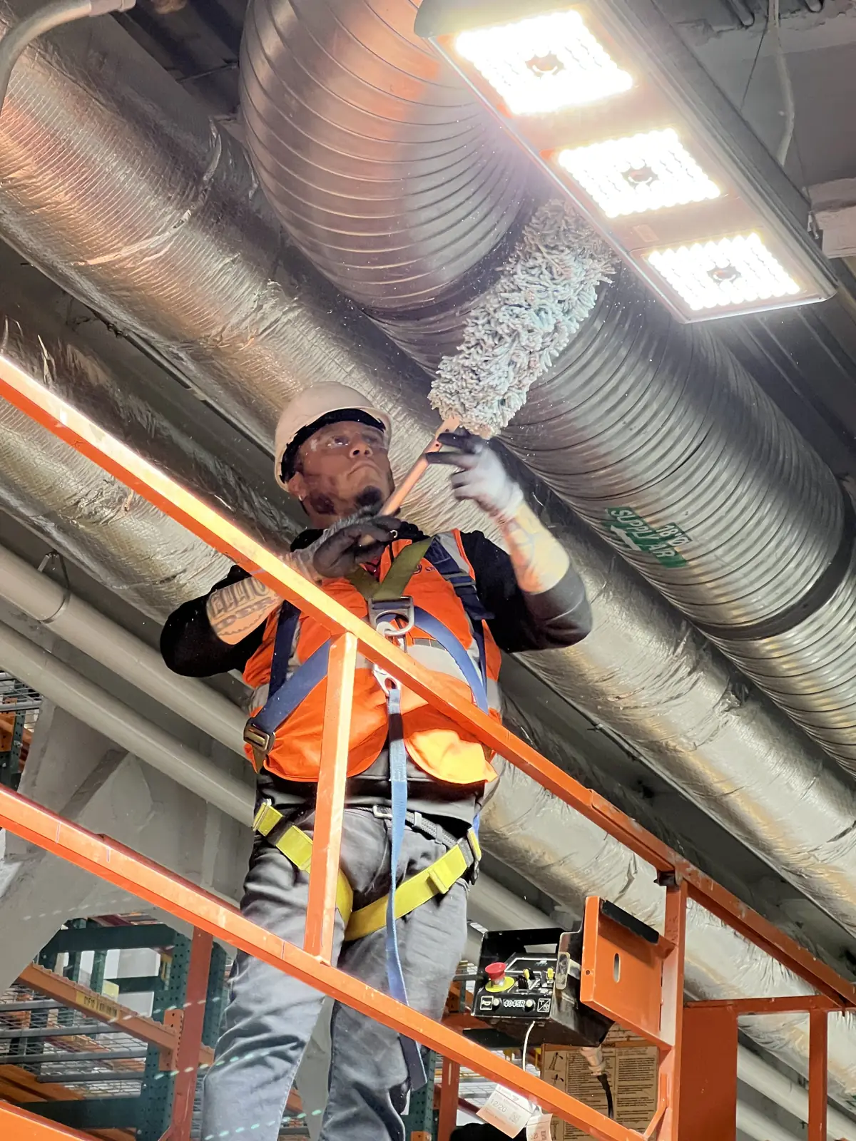 High dusting of overhead ductwork from an aerial lift