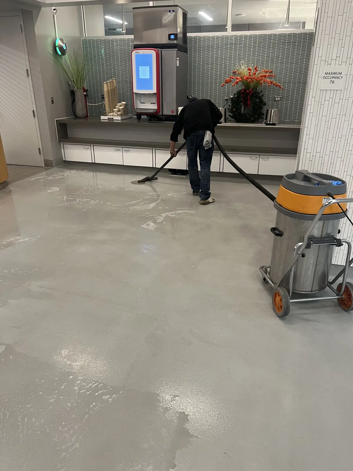 Nexara crew member scrubbing a lab floor with a wet vacuum